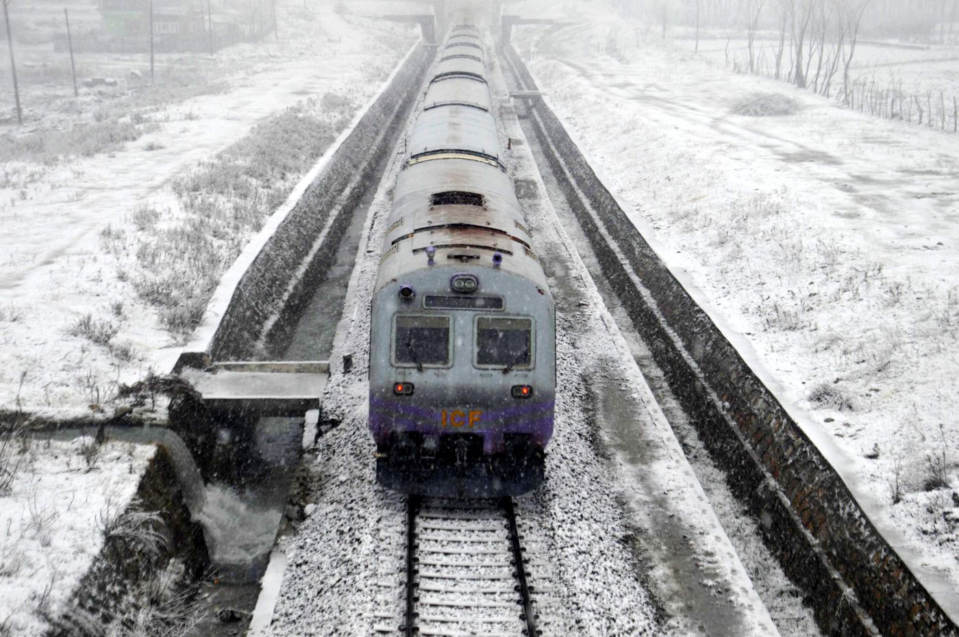 Train chugs through snow-clad tracks as several areas in south Kashmir …