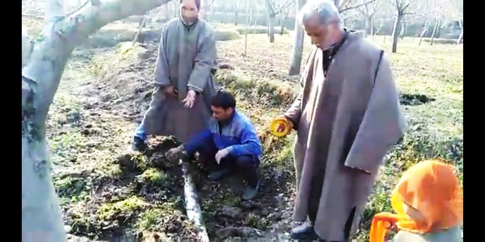 Exposed water pipeline running through orchids in Sempora Kulgam; orchardists fear soil erosion