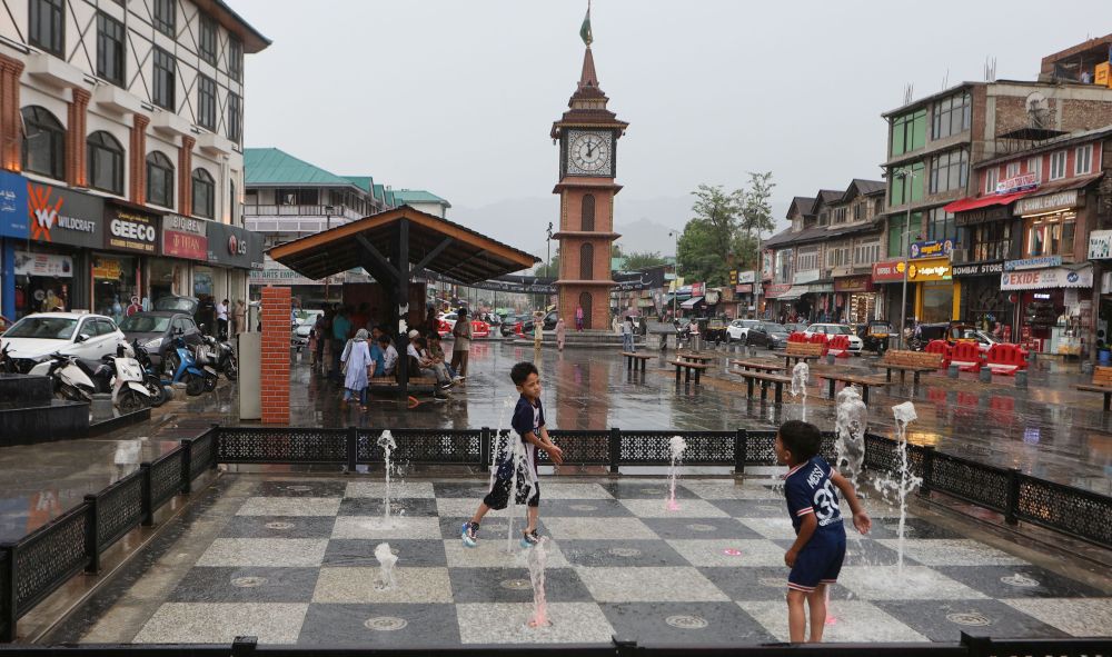 With Clock Tower standing tall in Lal Chowk, kids enjoy the much awaited drizzle on Monday