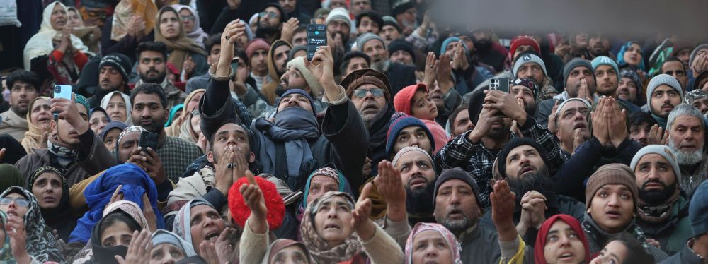 Devotees raise their hands in supplication at Dargah Hazratbal as the Holy Relic of the Prophet (SAW) is displayed on the eve of Shab-e-Miraj on Tuesday evening
