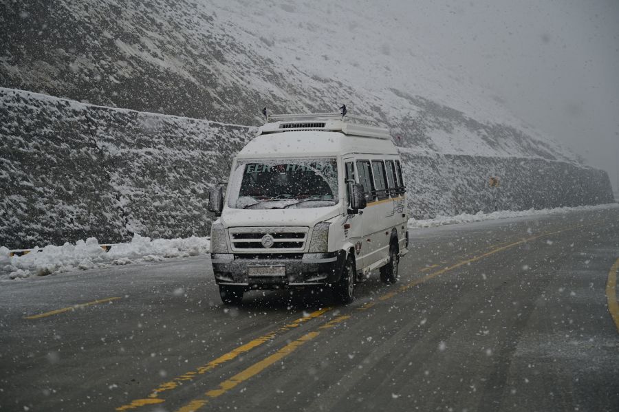 Amid fresh snowfall, a vehicle moves on Srinagar-Leh Highway near Gagangeer on Saturday