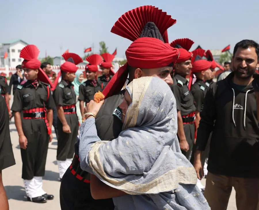 A mother of a Kashmiri youth hugs her son as he joins JAKLI of Indian Army