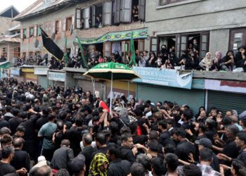 Women devotees watch from rooftops and windows as thousands take part in the Zuljinah procession in downtown Srinagar
