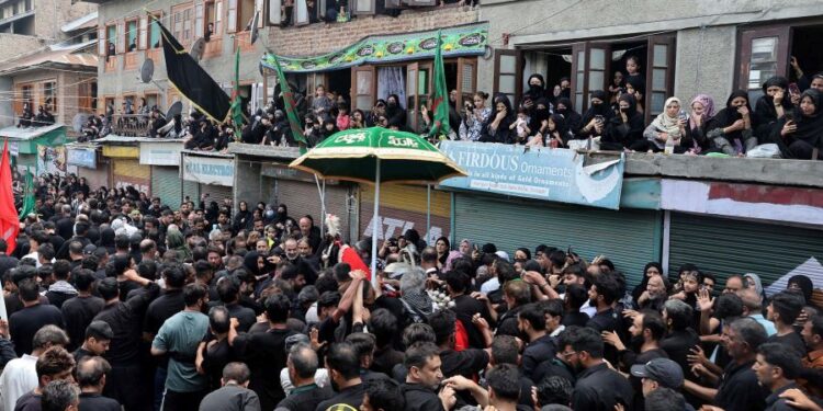 Women devotees watch from rooftops and windows as thousands take part in the Zuljinah procession in downtown Srinagar