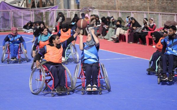 Female students with special needs play a game of sitting volleyball at a volunteer-run Medicare society in Srinagar