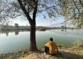A man enjoys a quiet moment fishing at the serene Chatlam Wetland in Pampore, South Kashmir, a haven for migratory birds and nature lovers alike.