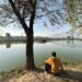 A man enjoys a quiet moment fishing at the serene Chatlam Wetland in Pampore, South Kashmir, a haven for migratory birds and nature lovers alike.