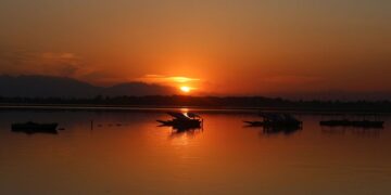 Sunset paints the waters of Dal Lake in golden hues as shikaras rest along the calm waters in Srinagar on Friday.