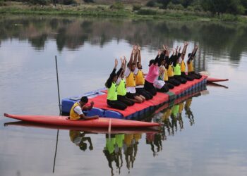 Participants perform yoga on a floating platform during an event marking International Yoga Day at Pokhrabal Lake in Srinagar.