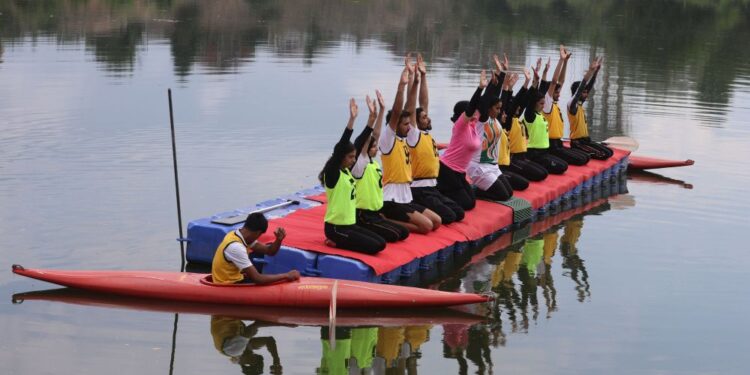 Participants perform yoga on a floating platform during an event marking International Yoga Day at Pokhrabal Lake in Srinagar.